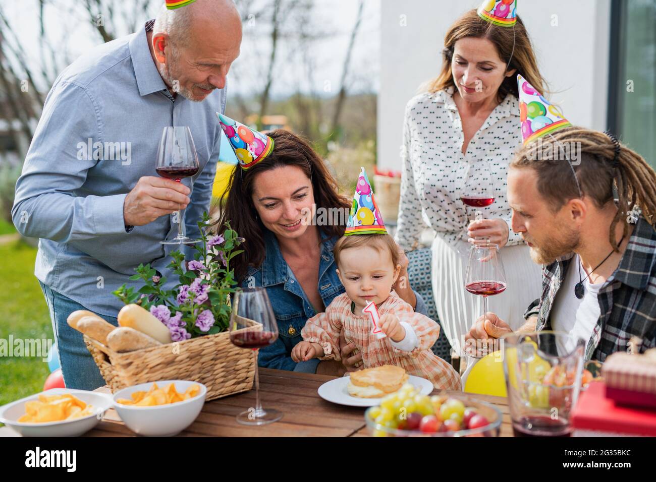 Feliz familia de varias generaciones al aire libre en el jardín en casa, fiesta de cumpleaños. Foto de stock
