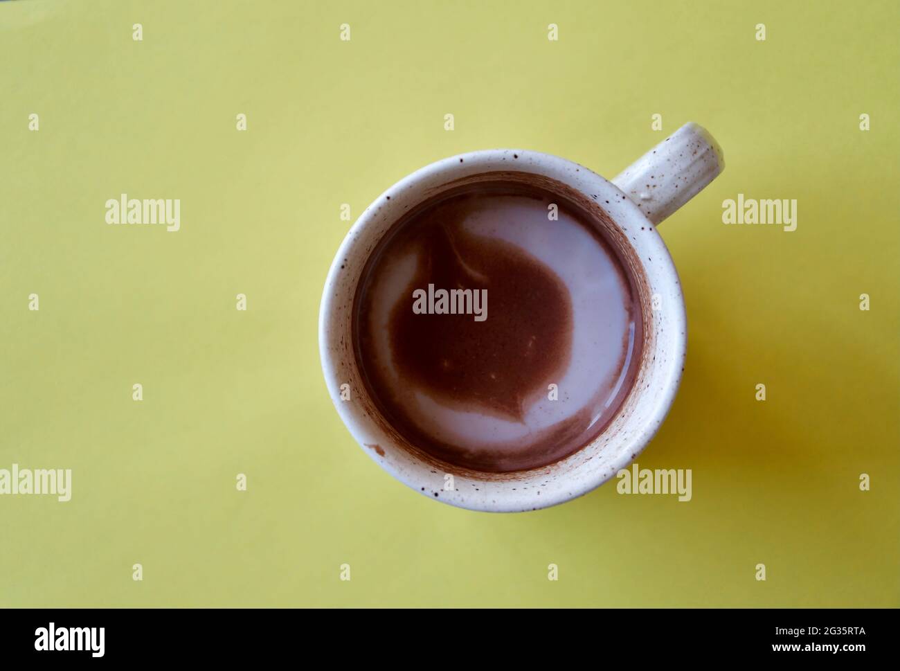 Foto de arriba de una taza de chocolate caliente sobre fondo amarillo Foto de stock