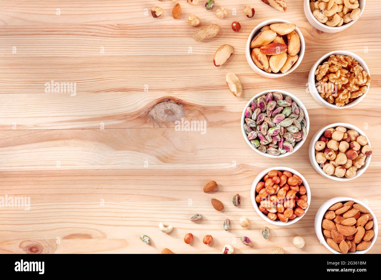 Las tuercas, sobre la cabeza plana se tiraron sobre una mesa de madera con un lugar para el texto. Aperitivos vegetarianos saludables Foto de stock