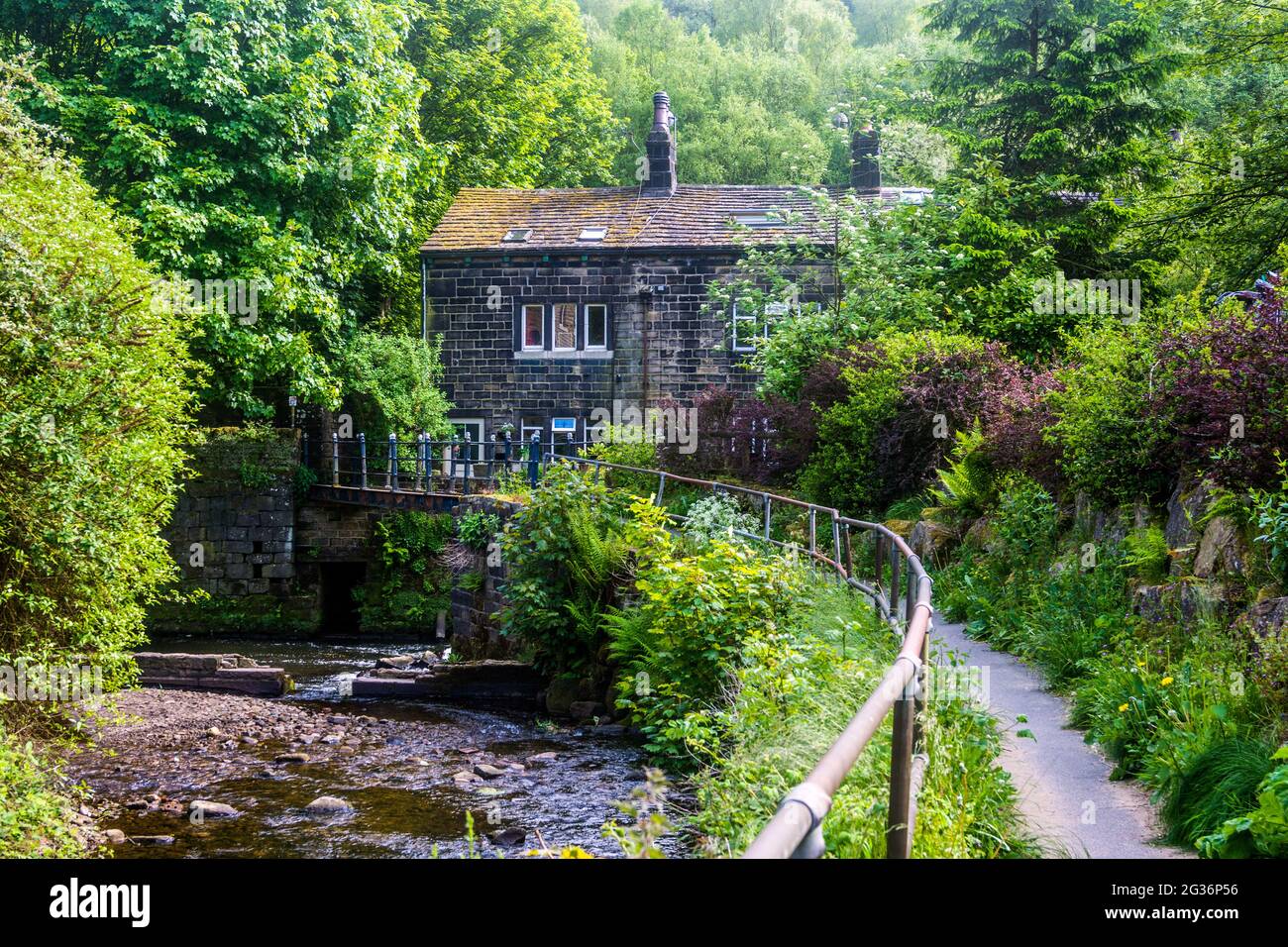 Una casa está situada en un bosque junto al río Calder, cerca del puente Hebden, Yorkshire, Reino Unido. Foto de stock