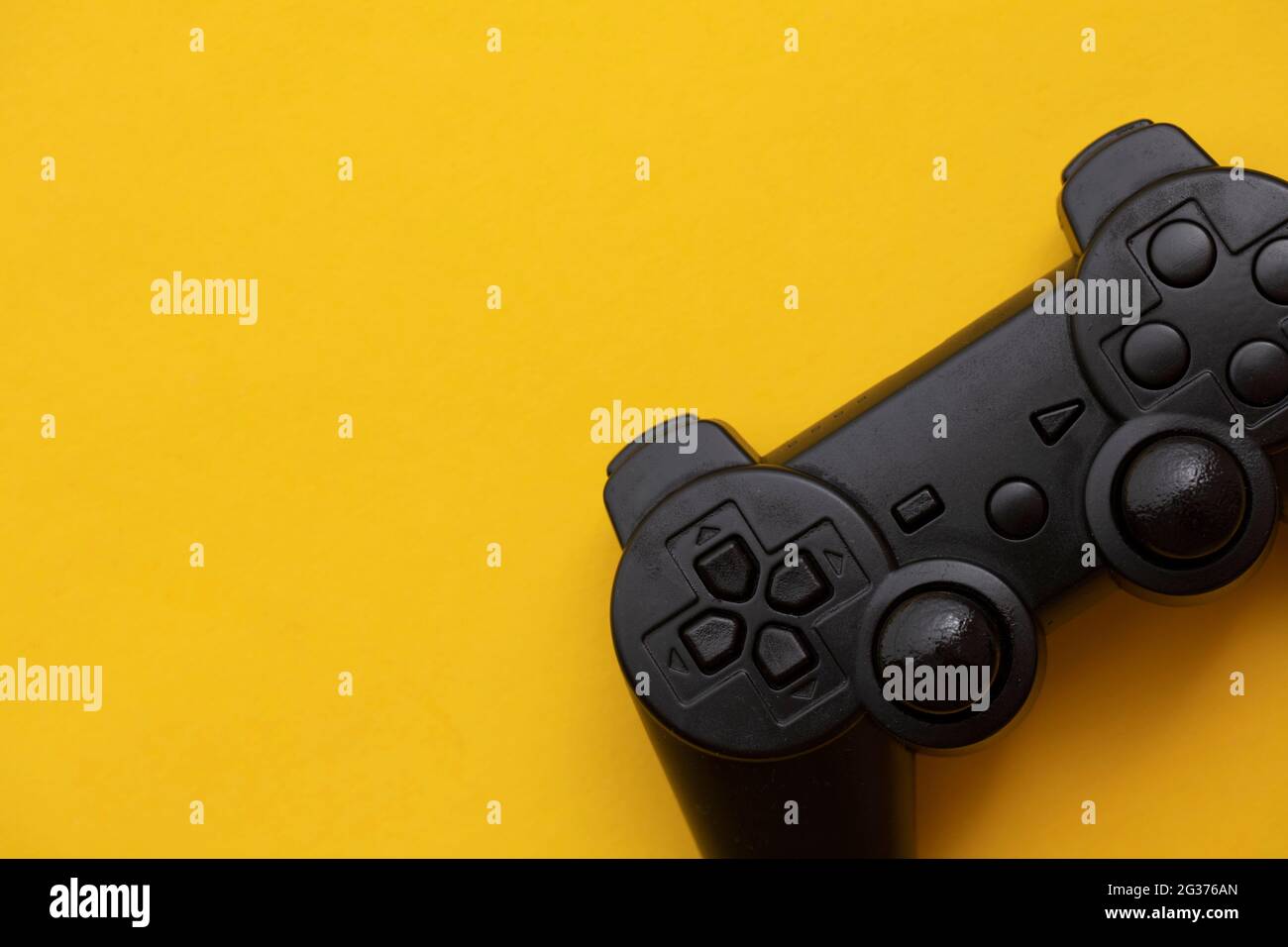 Dispositivo de video juego negro sobre fondo amarillo brillante Foto de stock