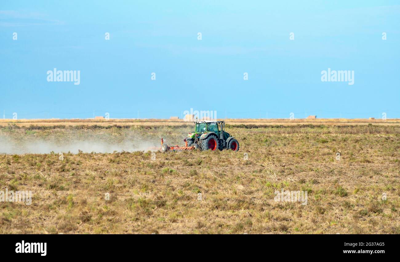 Tractor con arado en campo seco, Andalucía, España Foto de stock