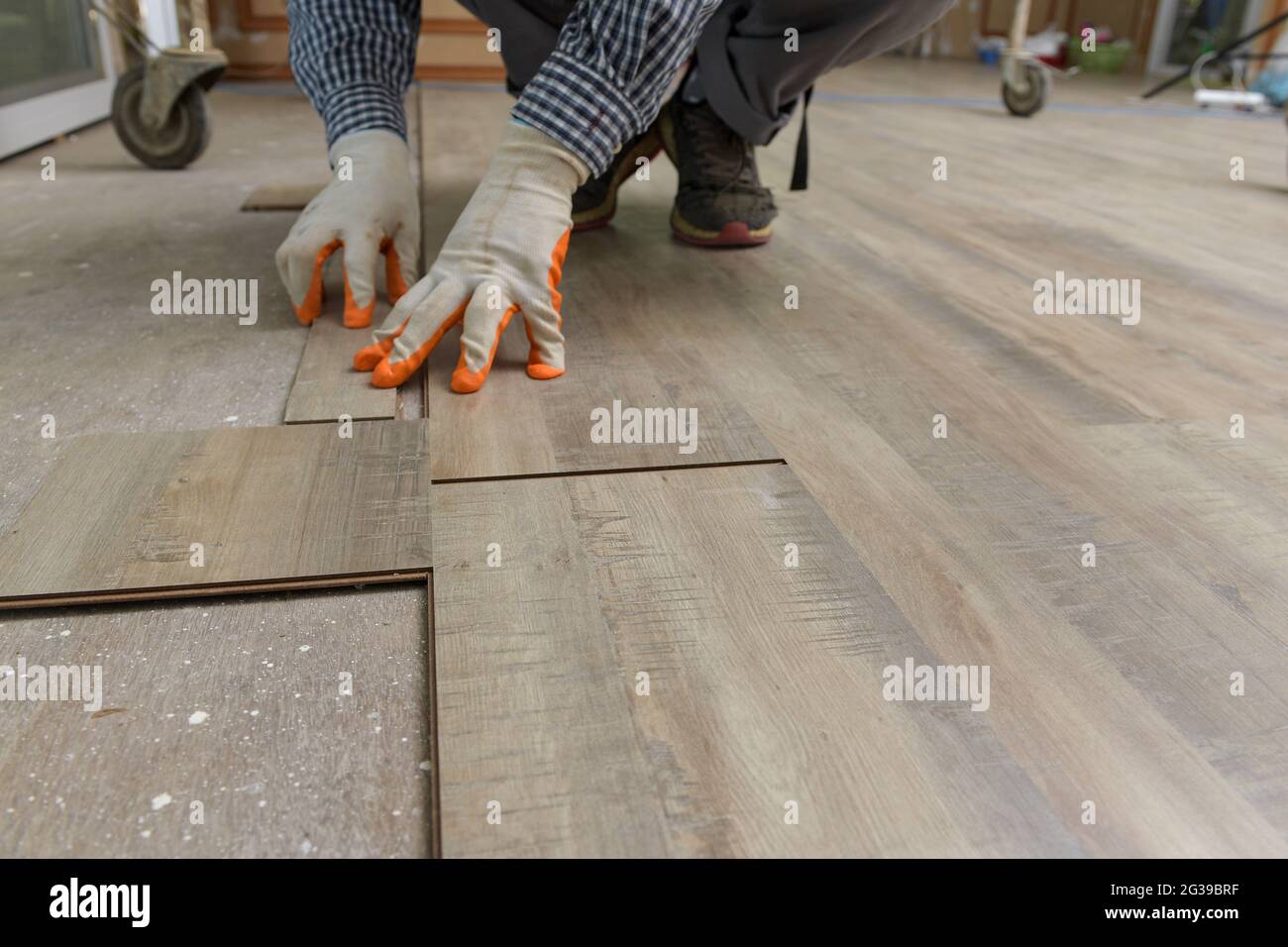Hogar de mejora de azulejos - handyman con level.Tiler trabaja con el suelo Foto de stock