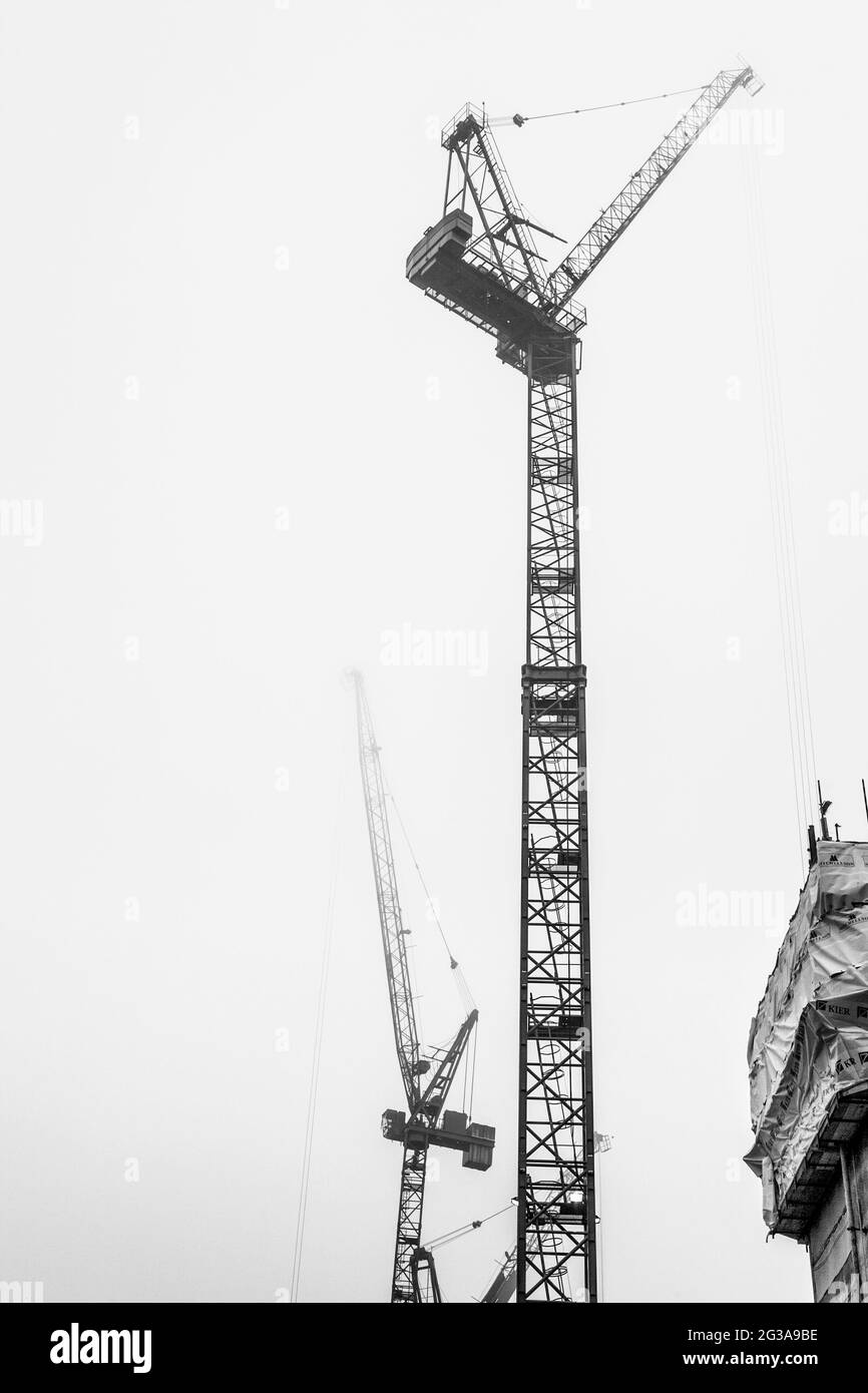 Grúas de construcción altas en la niebla en Kings Cross, Londres, Reino Unido Foto de stock