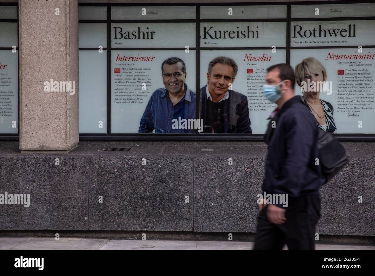 Los viajeros pasan por delante de una imagen de Martin Bashir en el 'Muro de la Fama' del King's College en el campus Strand, en el centro de Londres, que se va a desmarcar. Foto de stock