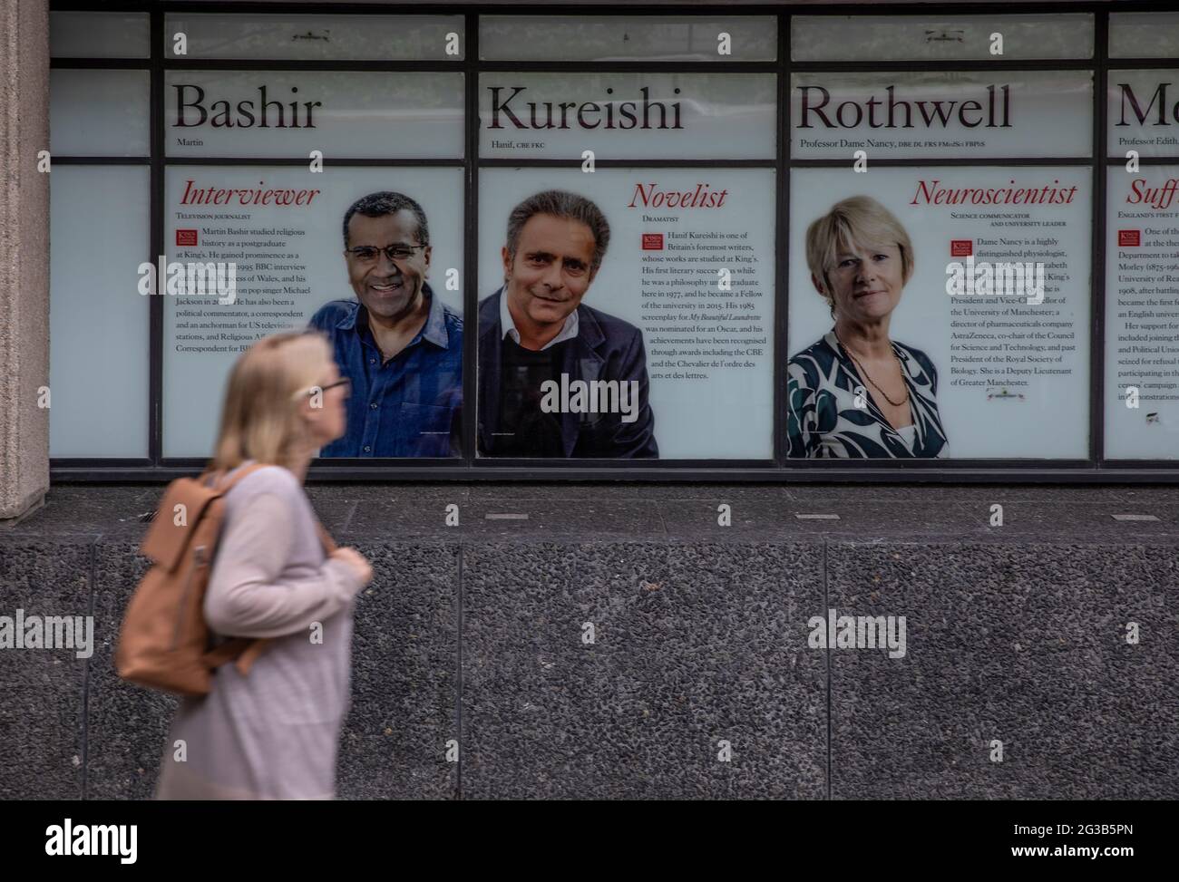 Los viajeros pasan por delante de una imagen de Martin Bashir en el 'Muro de la Fama' del King's College en el campus Strand, en el centro de Londres, que se va a desmarcar. Foto de stock