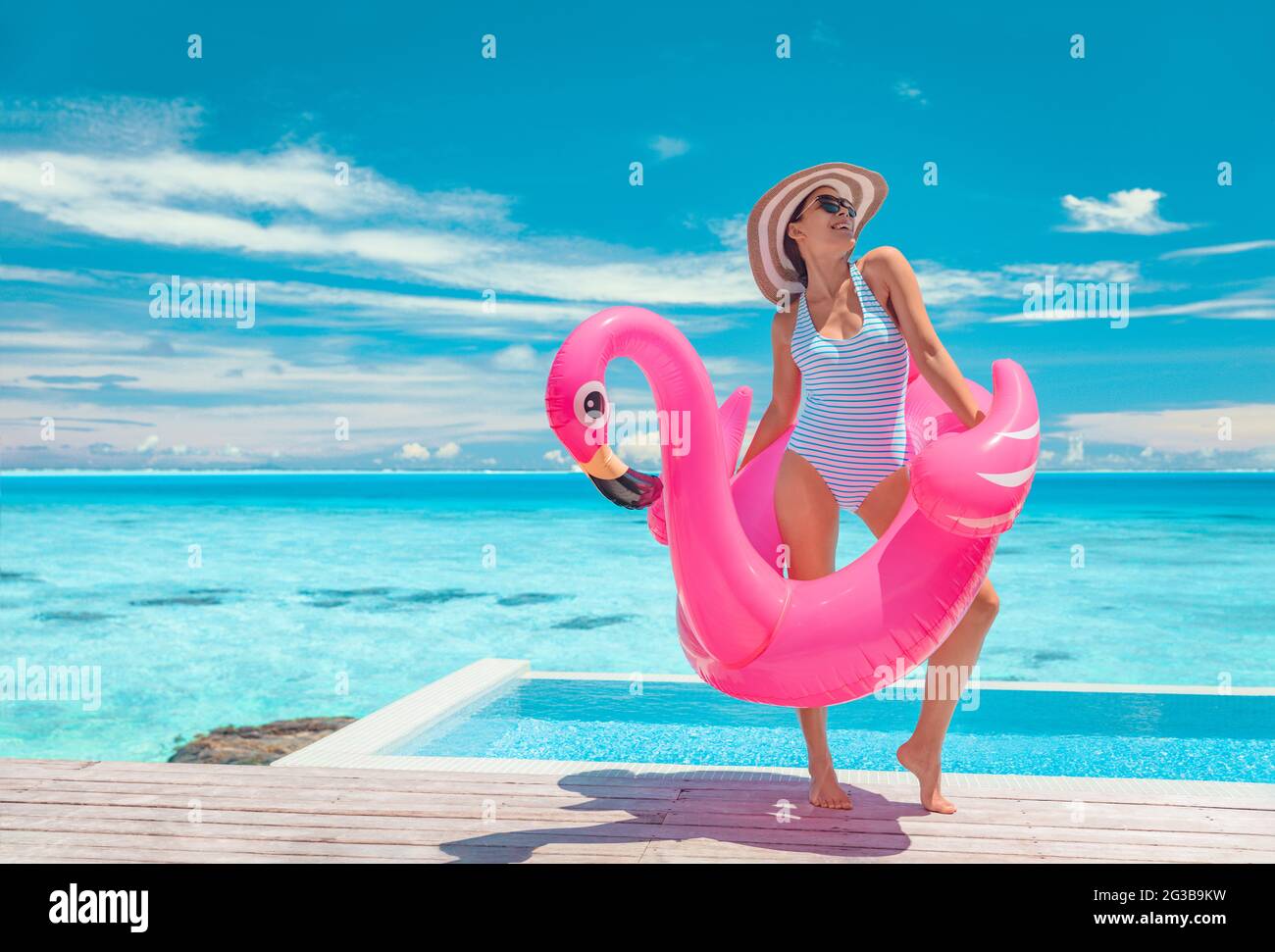 Piscina de verano divertido modelo de traje de baño posando en rosa flamingos flotando mostrando la figura delgada bikini cuerpo listo una escapada de vacaciones de lujo en el Caribe. Mujer