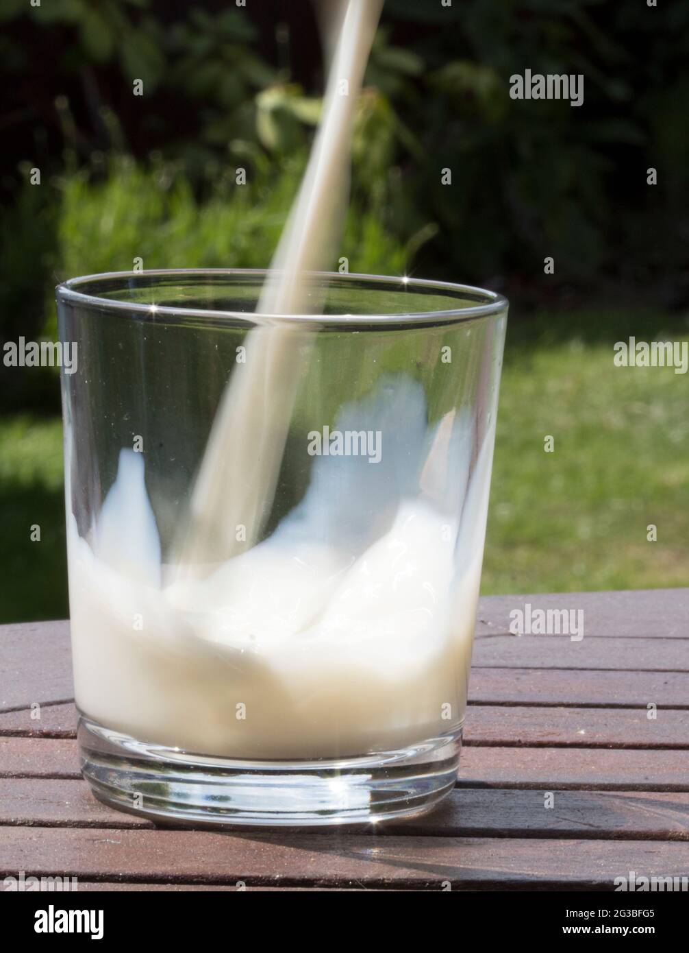 Verter en el vaso de leche Foto de stock