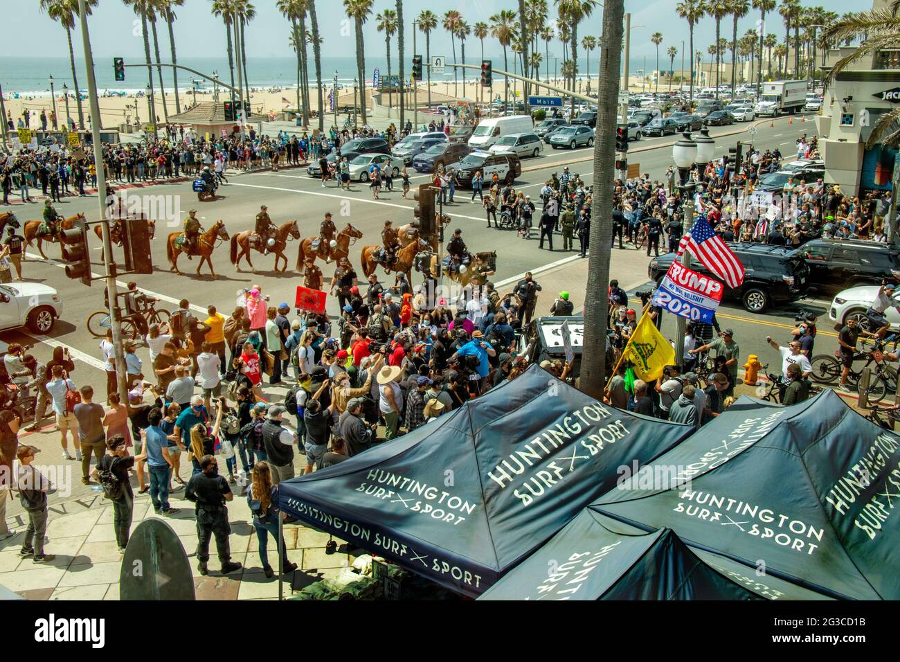 Los diputados del sheriff montado llegan cuando los partidarios caucásicos de Donald Trump se reúnen para protestar por su derrota electoral de 2020 en Huntington Beach, CA. Foto de stock