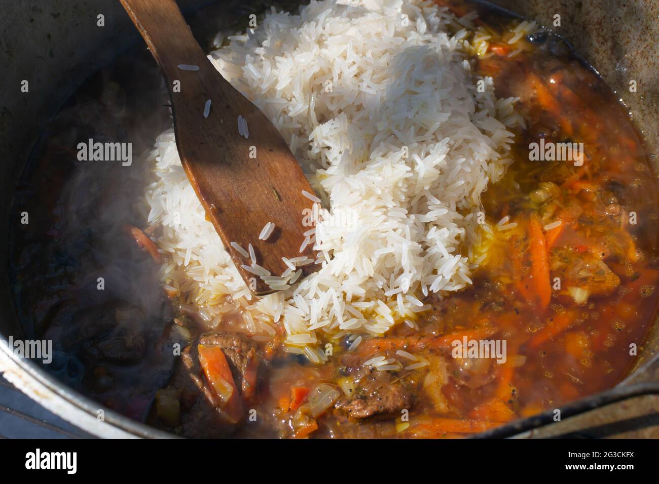 https://c8.alamy.com/compes/2g3ckfx/cocina-tradicional-pilaf-oriental-en-un-caldero-sobre-un-fuego-el-arroz-lavado-se-vierte-en-un-zervak-para-la-carne-y-las-verduras-guisadas-2g3ckfx.jpg