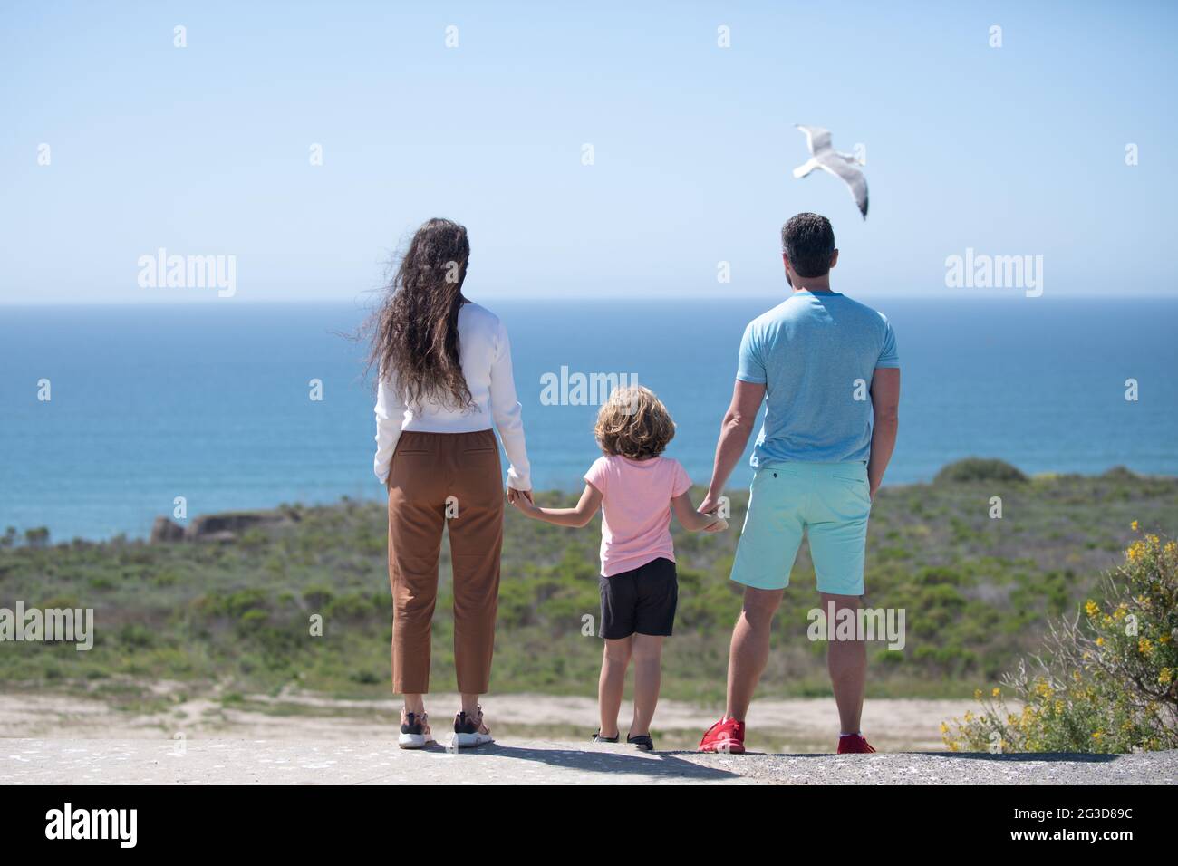 Padre, madre y niño en la playa de verano al atardecer en Hawai. Concepto de familia amigable. Foto de stock