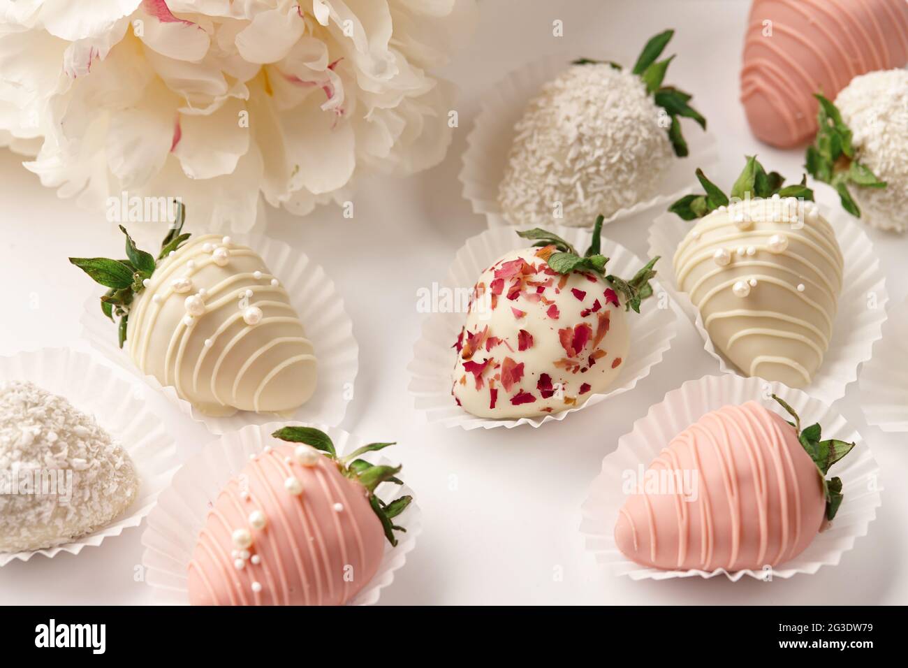 Fresas de chocolate blanco y rosa bañadas en mesa blanca Fotografía de  stock - Alamy