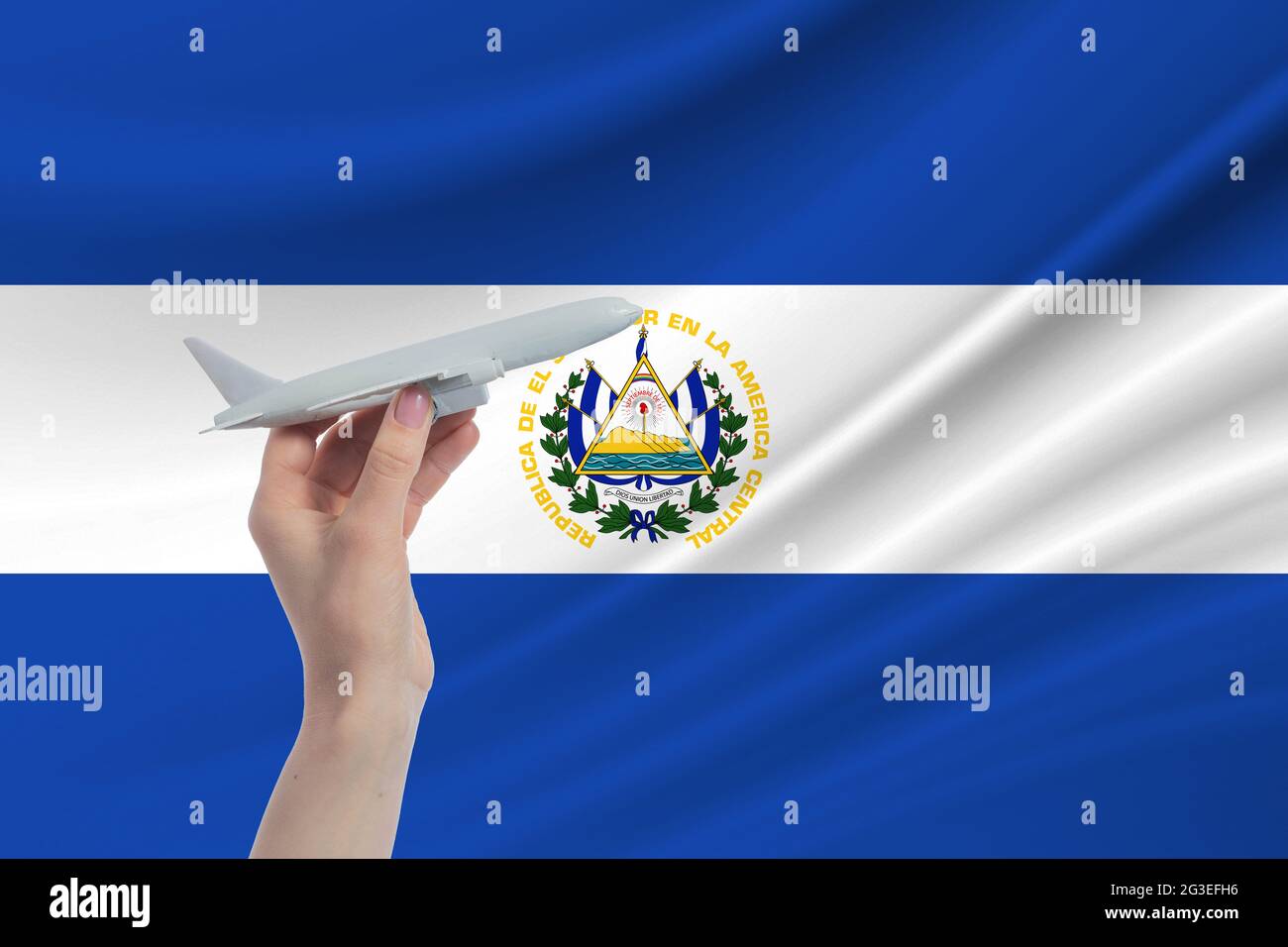 Avión en mano con bandera nacional de El Salvador. Viaje a El Salvador  Fotografía de stock - Alamy