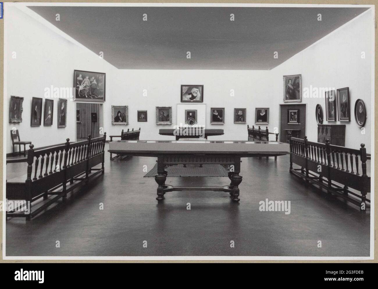 Habitación con pinturas y en el medio dos mesas de rin; tres siglos retrato en los Países Bajos. Sala central en el patio oriental con enlaces de un pasaje y en el medio detrás de un retrato redondo en una mesa. Foto de stock