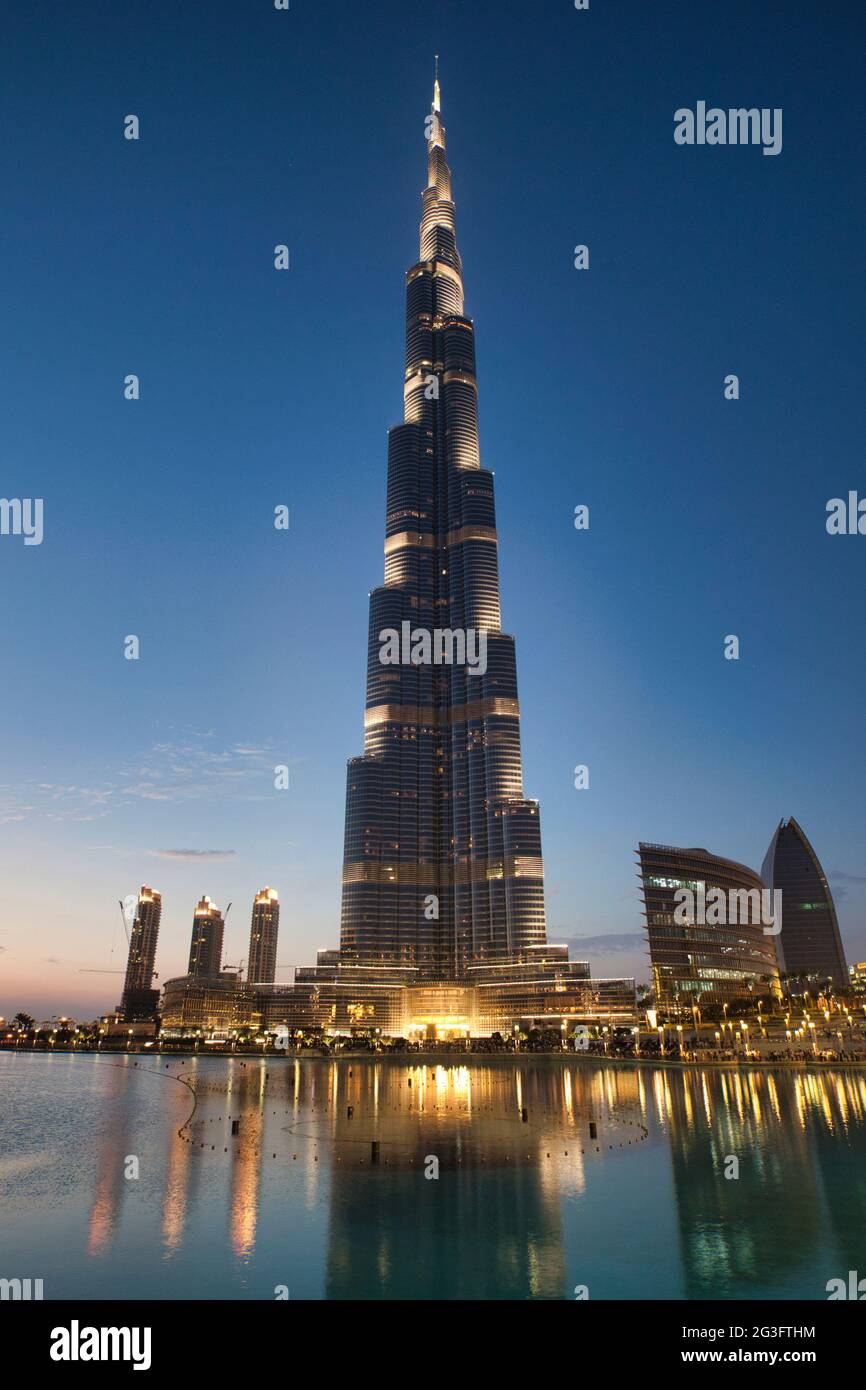 El edificio más alto del mundo, el Burj Khalifa se iluminó al atardecer con reflejos en el lago en frente, Dubai, los Emiratos Árabes Unidos Foto de stock