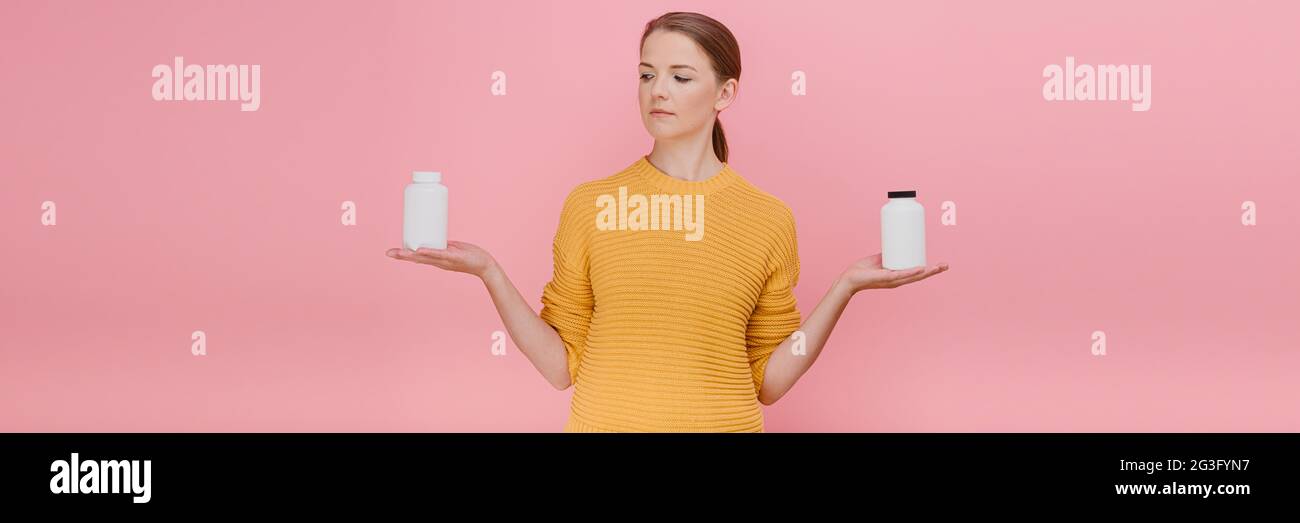 Hermosa mujer bonita elegir botella de píldoras médicas o vitaminas  casualmente vestido conjunto, teniendo dudoso tratamiento de expresión y la  prevención de disea Fotografía de stock - Alamy