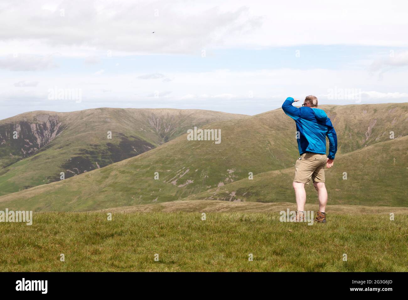 Un hombre mira desde Arant Haw en el Parque Nacional Yorkshire Dales. Mira hacia colinas cercanas. Foto de stock