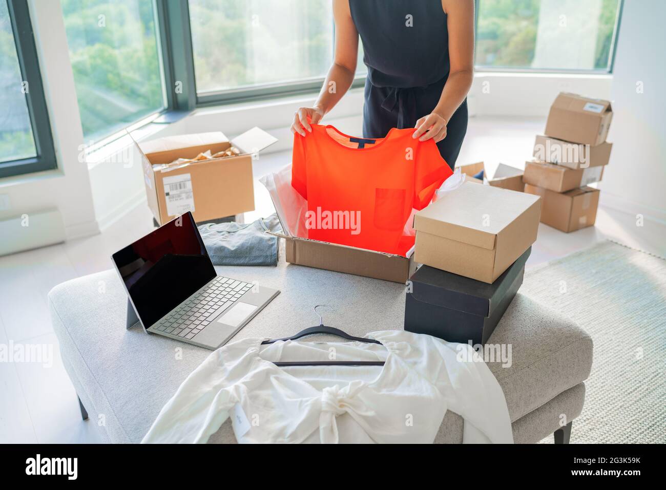Venta de ropa o usada en línea con la aplicación de Internet en la pantalla del ordenador Mujer ropa de moda en la caja de correo para el envío