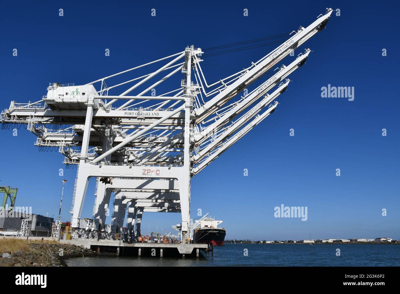 Los contenedores de transporte se cargan en los barcos en el Puerto de Oakland, California, uno de los puertos de carga más ocupados de la costa oeste. Foto de stock