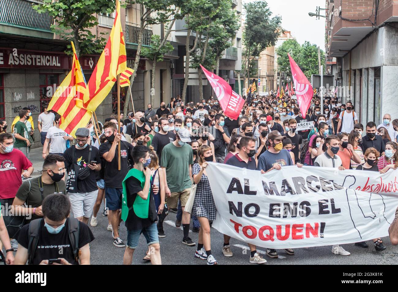 Los manifestantes marchan por la calle mientras sostenían una bandera y banderas durante la manifestación.Cientos de personas se han manifestado en Badalona, una ciudad al lado de Barcelona en solidaridad con Marcel Vivet, Quién ha sido condenado a cinco años de prisión por los incidentes ocurridos en una manifestación de independencia catalana en septiembre de 2018 en Barcelona contra un acto del sindicato de policía, Jusapol (Justicia del Salario Policial). Vivet ha sido juzgado por un delito de desorden público y ataque contra un agente de la autoridad. A la manifestación asistió Dolors Sabater, diputado del Parlamento de Cat Foto de stock