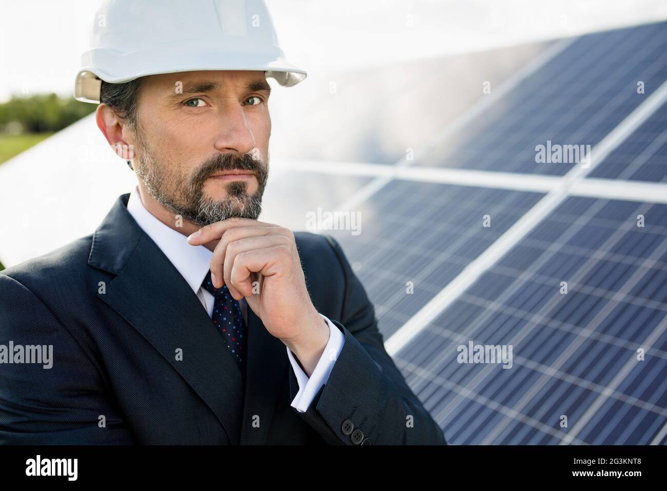 Retrato de cliente en un casco blanco en la estación de energía solar. Foto de stock