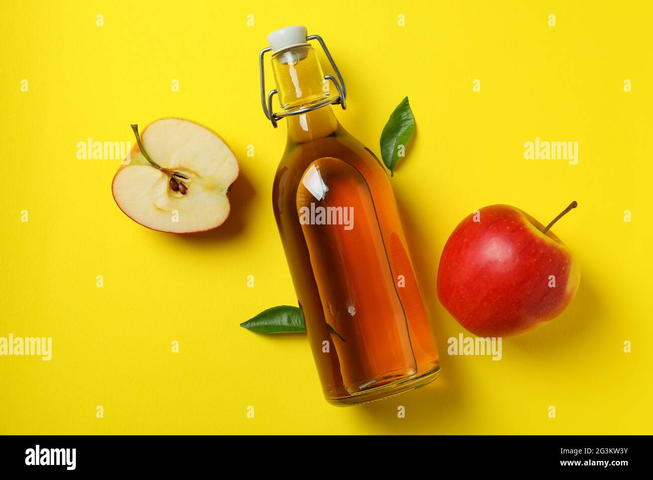 Vinagre de manzana casero e ingredientes sobre fondo amarillo Fotografía de  stock - Alamy