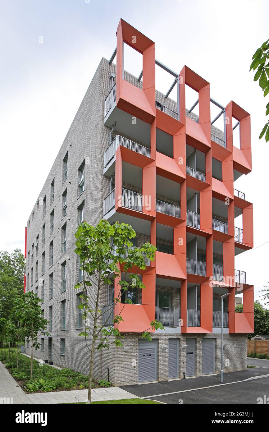 Paneles de cemento reforzado con vidrio (GRC), de color naranja y disicitivo, en un bloque de apartamentos de la Autoridad Local recientemente construido en Hackney, Londres, Reino Unido Foto de stock
