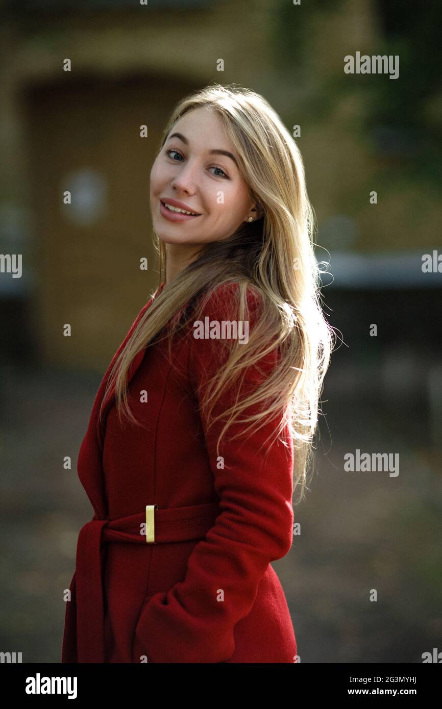 Mujer joven caminar Vestían casaca roja Foto de stock