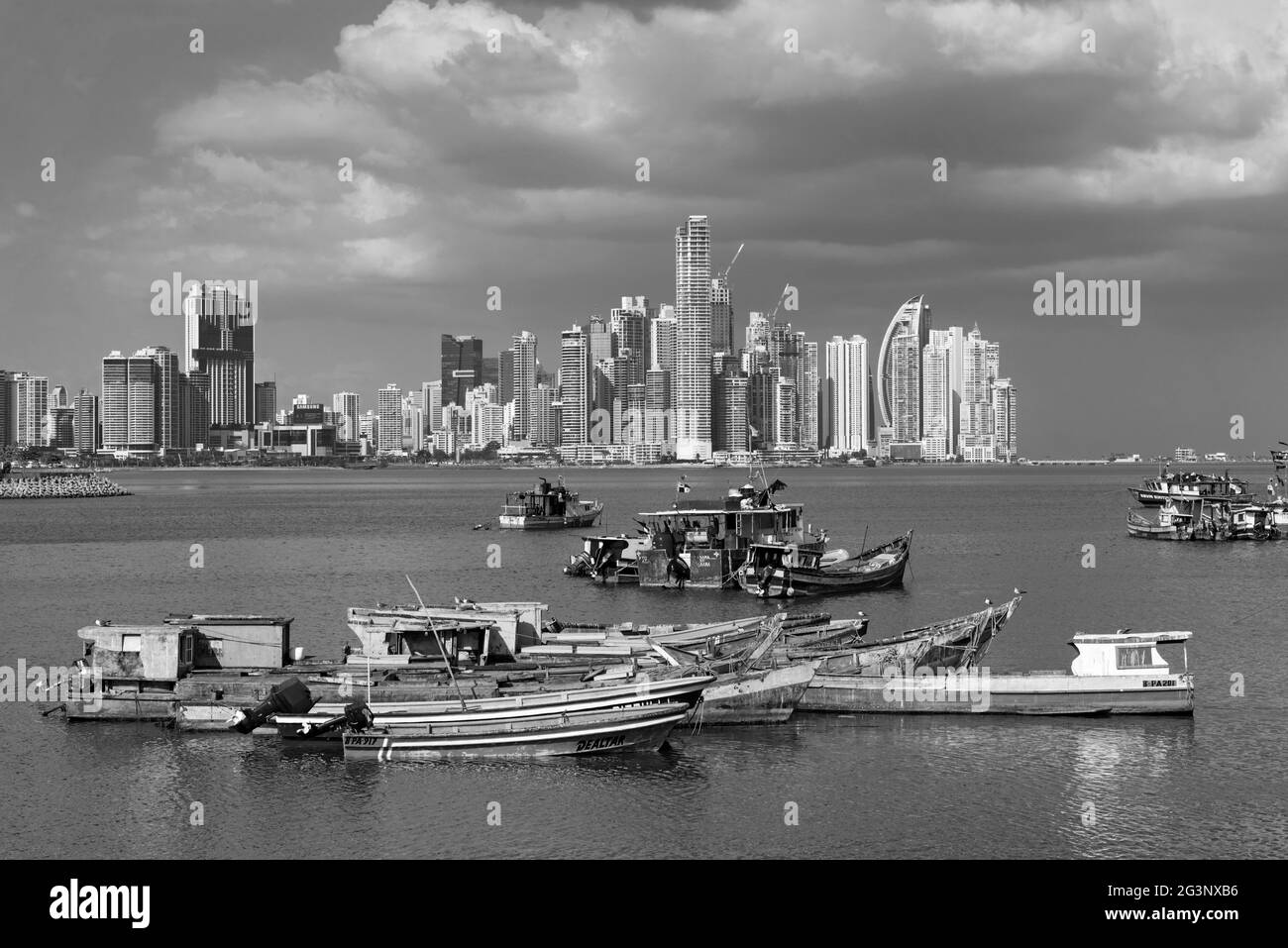 Viejos barcos de pesca de madera frente al horizonte de la ciudad de panamá en blanco y negro Foto de stock