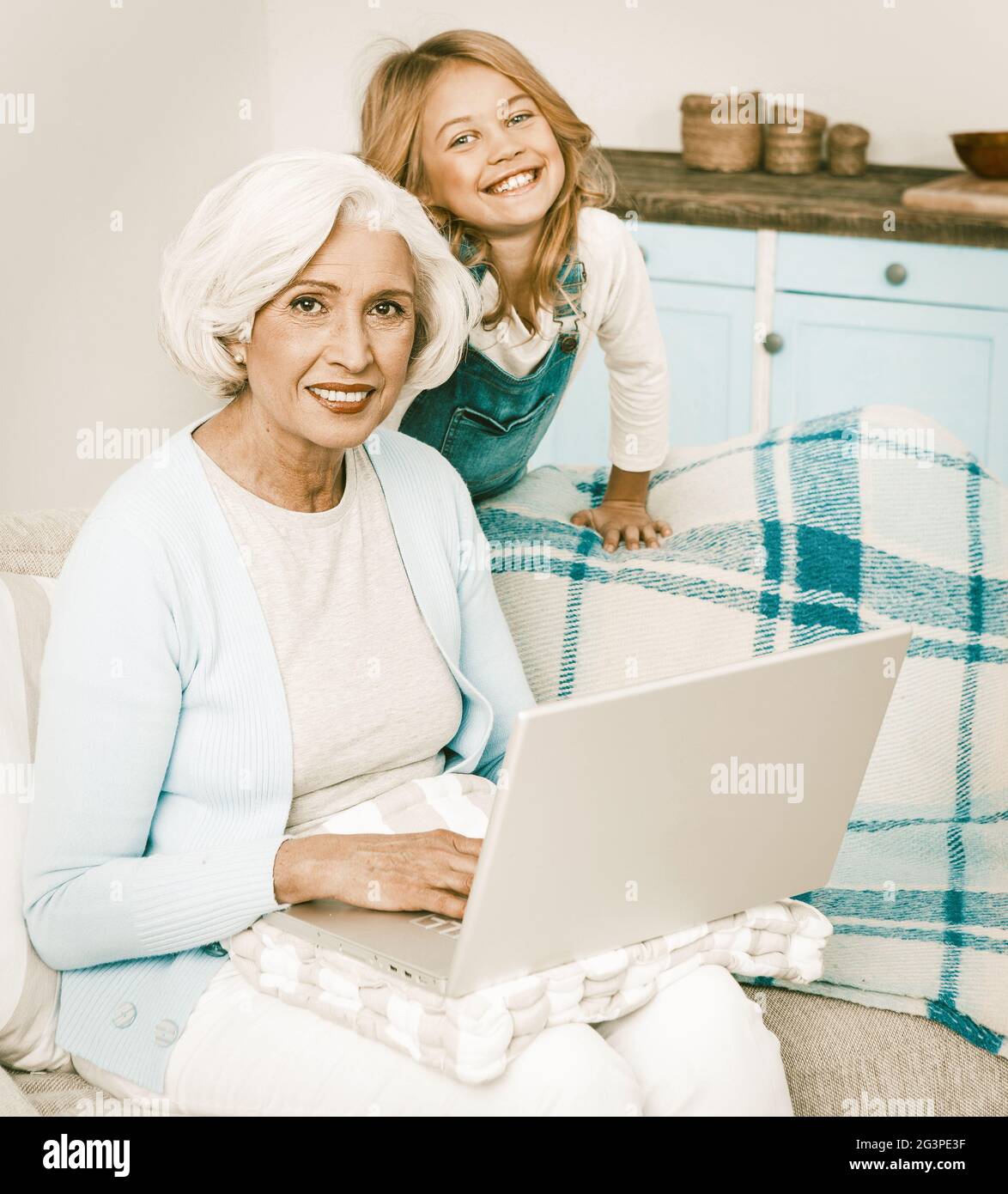 Abuela y nieta usando el ordenador portátil en casa Foto de stock