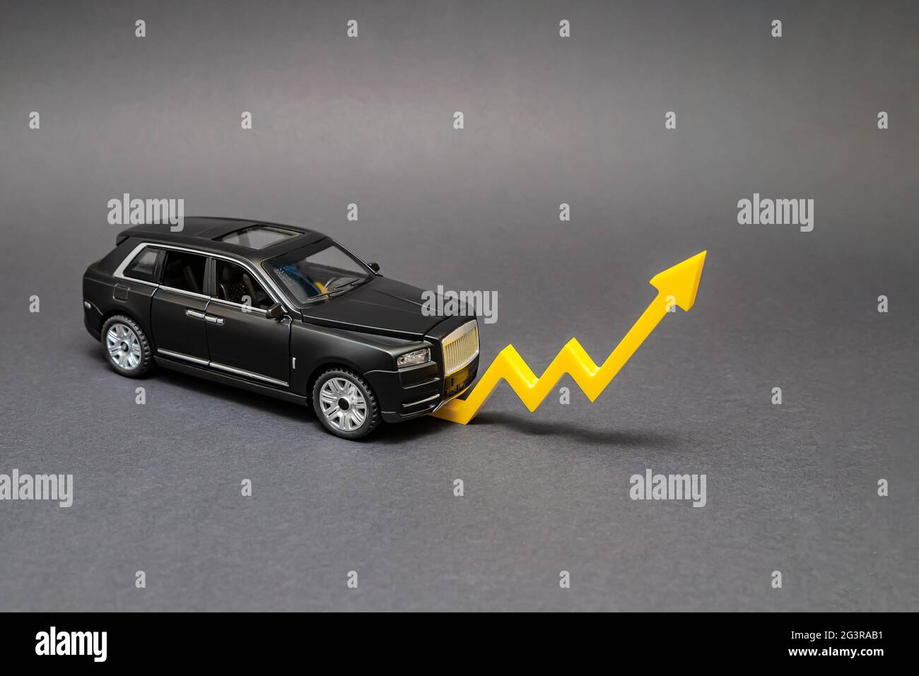 Aumento de los precios de los automóviles. Sobre un fondo negro, hay un  modelo de coche con una flecha amarilla apuntando hacia arriba. El concepto  de crecimiento del mercado del transporte Fotografía