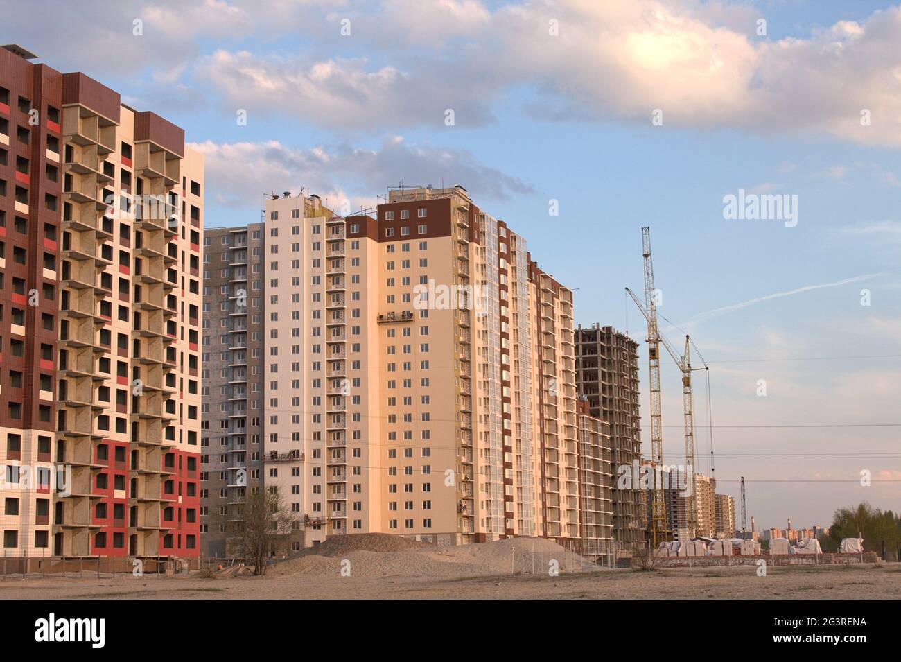 Se están construyendo edificios de apartamentos de varios pisos de ladrillos rojos, blancos y marrones con aberturas en las ventanas. Foto de stock