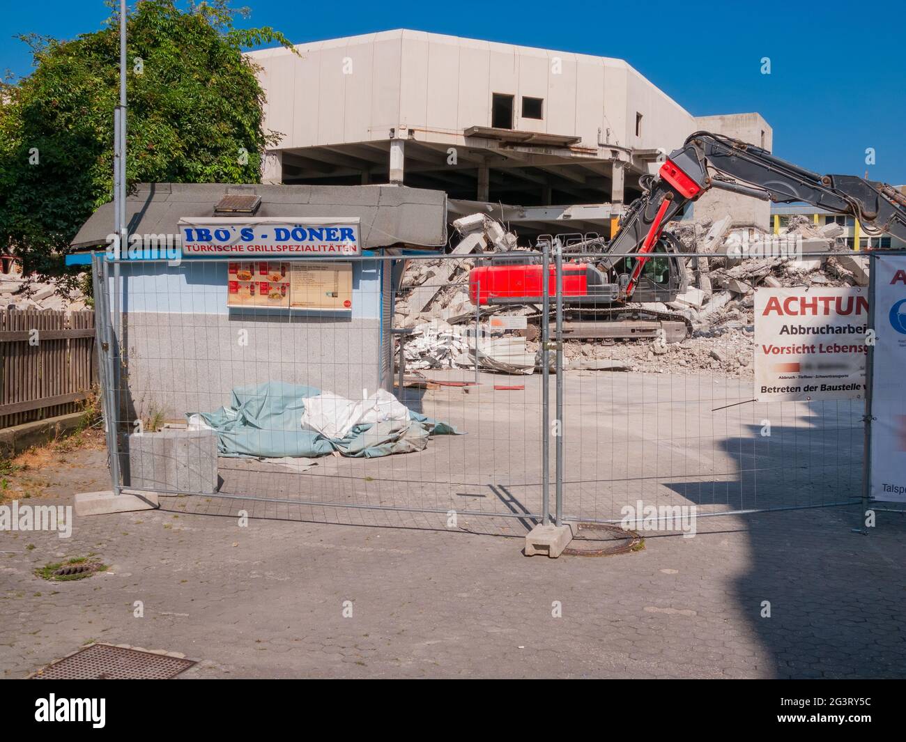 Excavadora de demolición junto a un snack bar abandonado DÃ¶ner Foto de stock