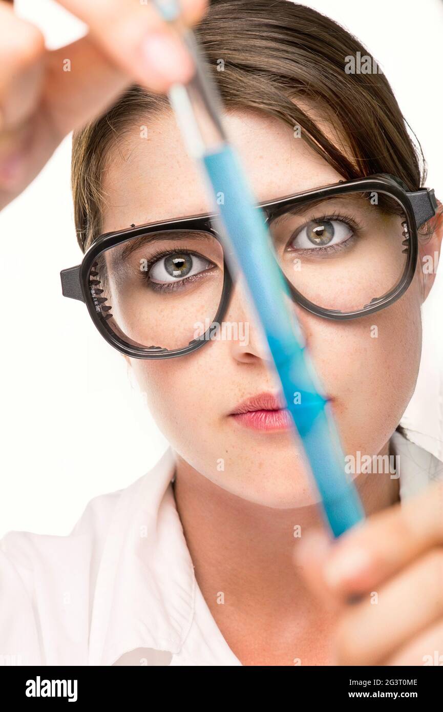 asistente de laboratorio con gafas de seguridad que examinan un tubo de ensayo en el laboratorio Foto de stock