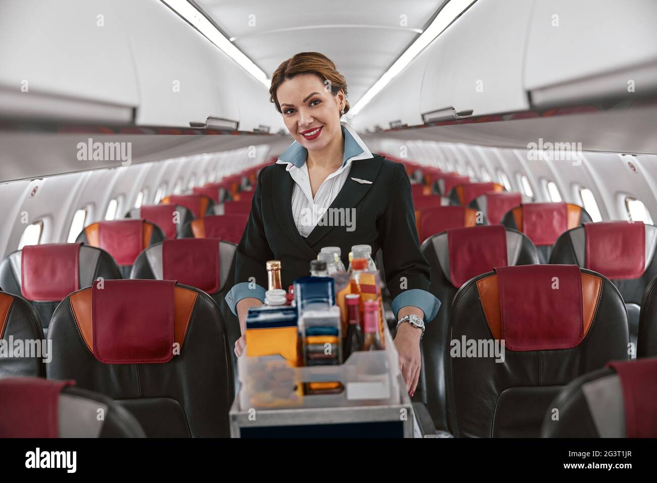 Azafata con carrito de comida en cabina de avión Fotografía de stock - Alamy