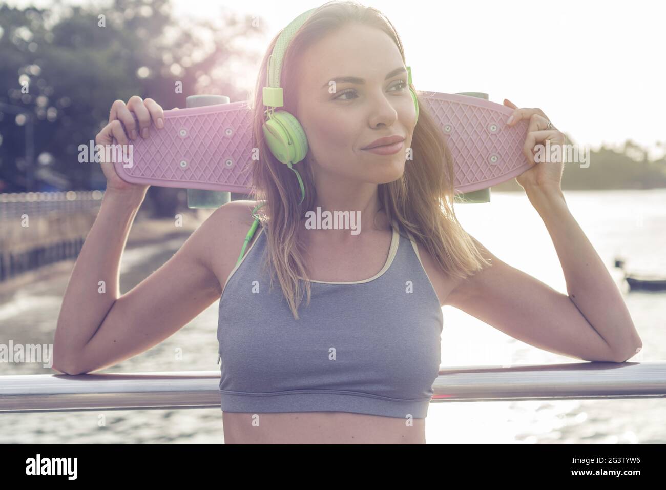 Mujer de ajuste relajado en ropa deportiva con auriculares elige música de  un teléfono inteligente para entrenar
