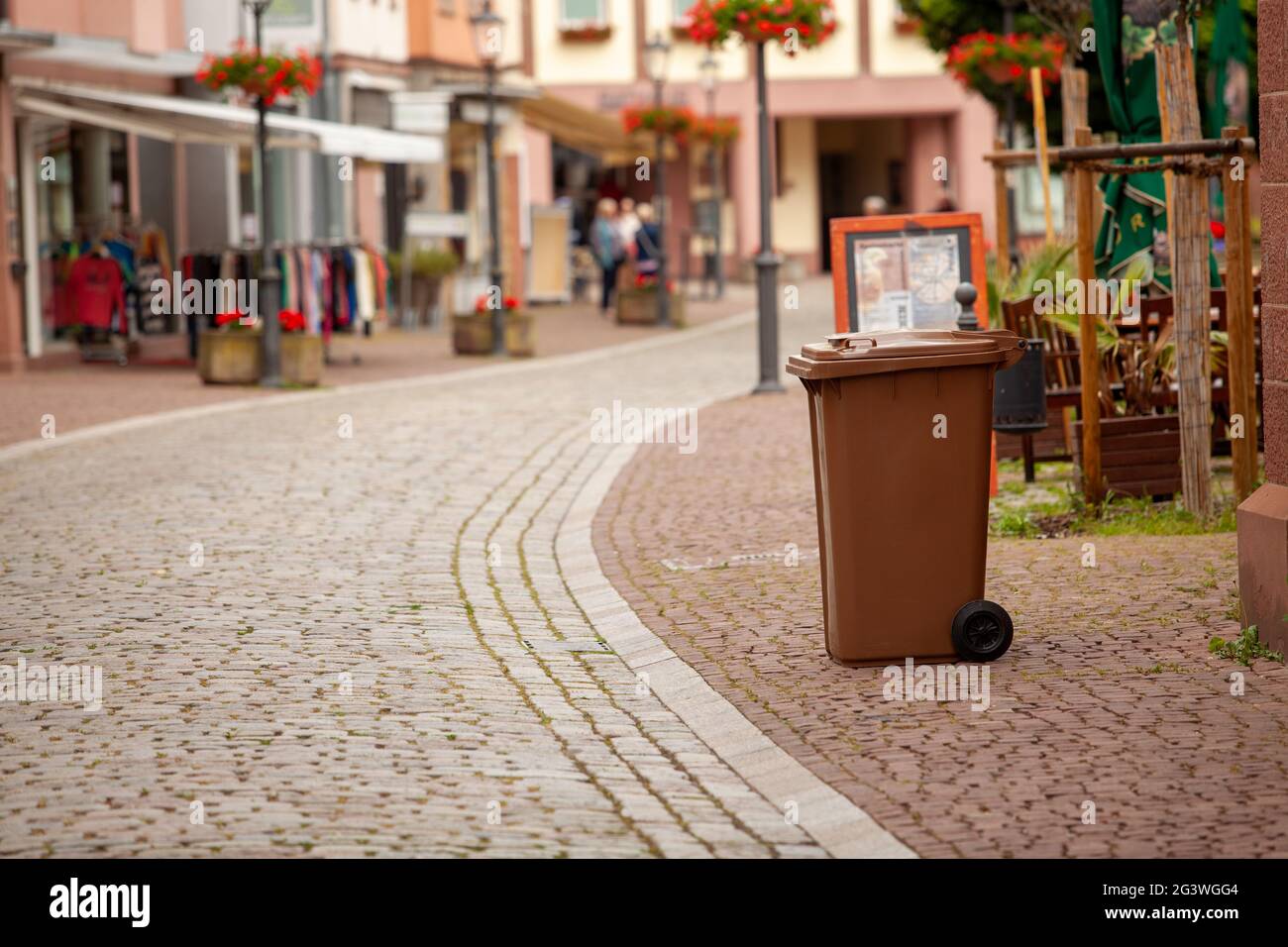 Un contenedor de basura se encuentra en la calle de un europeo Ciudad alemana Foto de stock