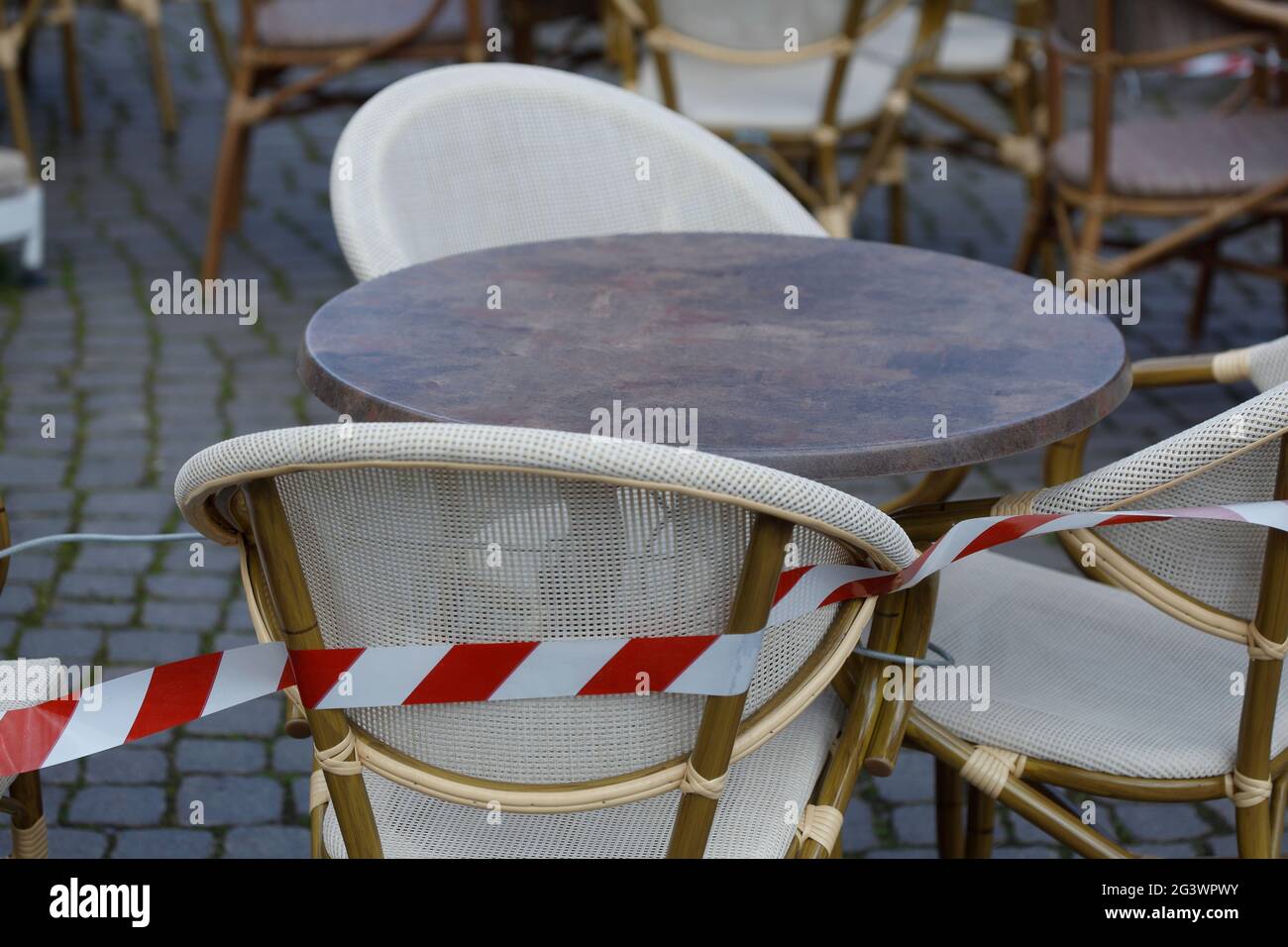 Cinta de barrera y sillas y mesas vacías de un café en el mercado de Bremen, cerrado por coronavirus, Bremen, Alemania, Europa Foto de stock