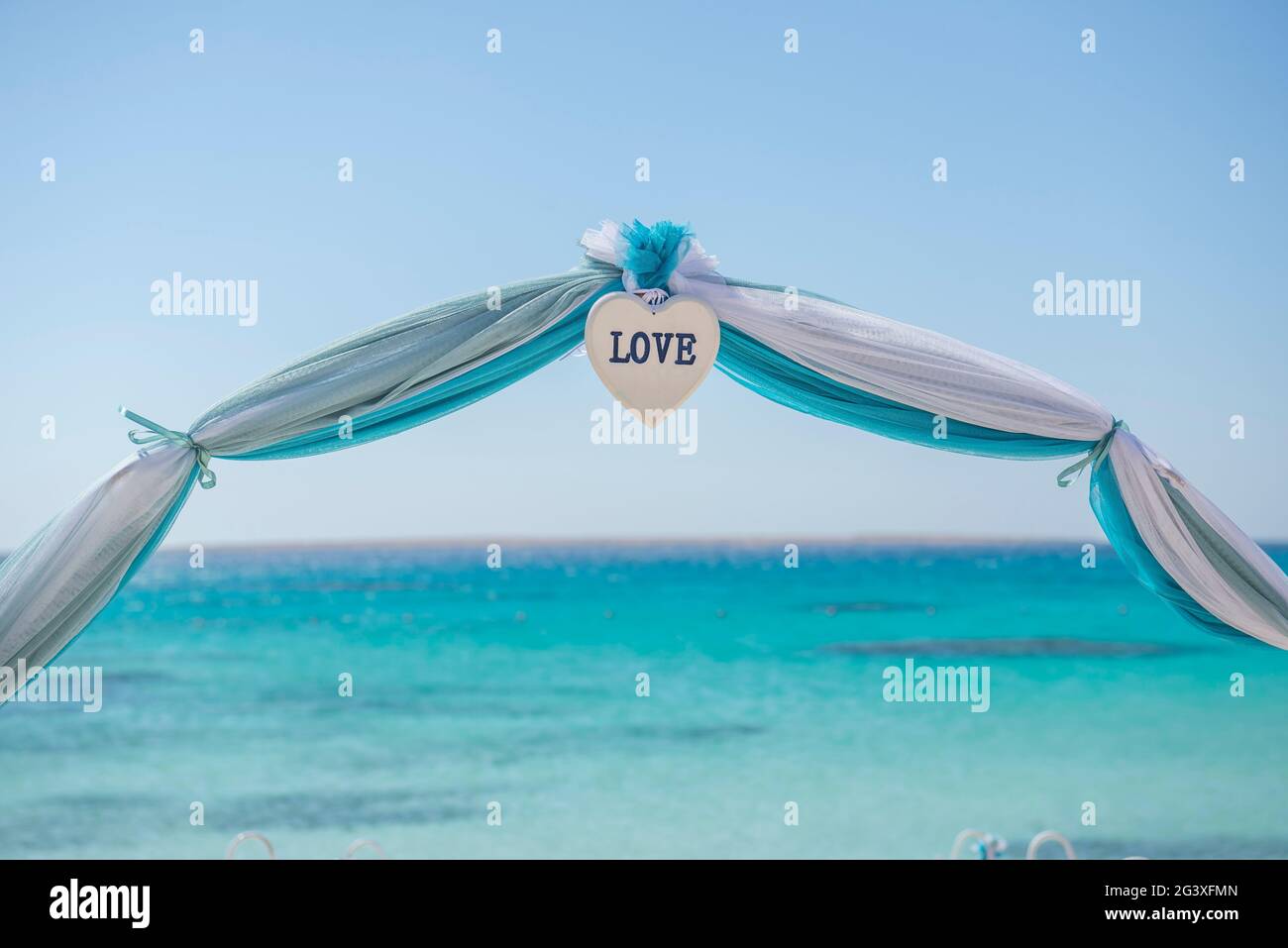 Configuración de boda matrimonio pasillo con cortinas y arco en Sandy Beach Paradise tropical al fondo del océano abierto Foto de stock