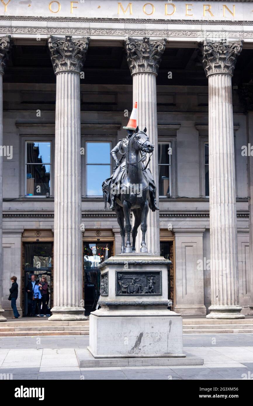 Estatua de Equestrain de Arthur Wellesley, el duque de Wellington de 1st fuera de la Galería de Arte Moderno, Glasgow.El cono de tráfico en su cabeza es un tradit Foto de stock