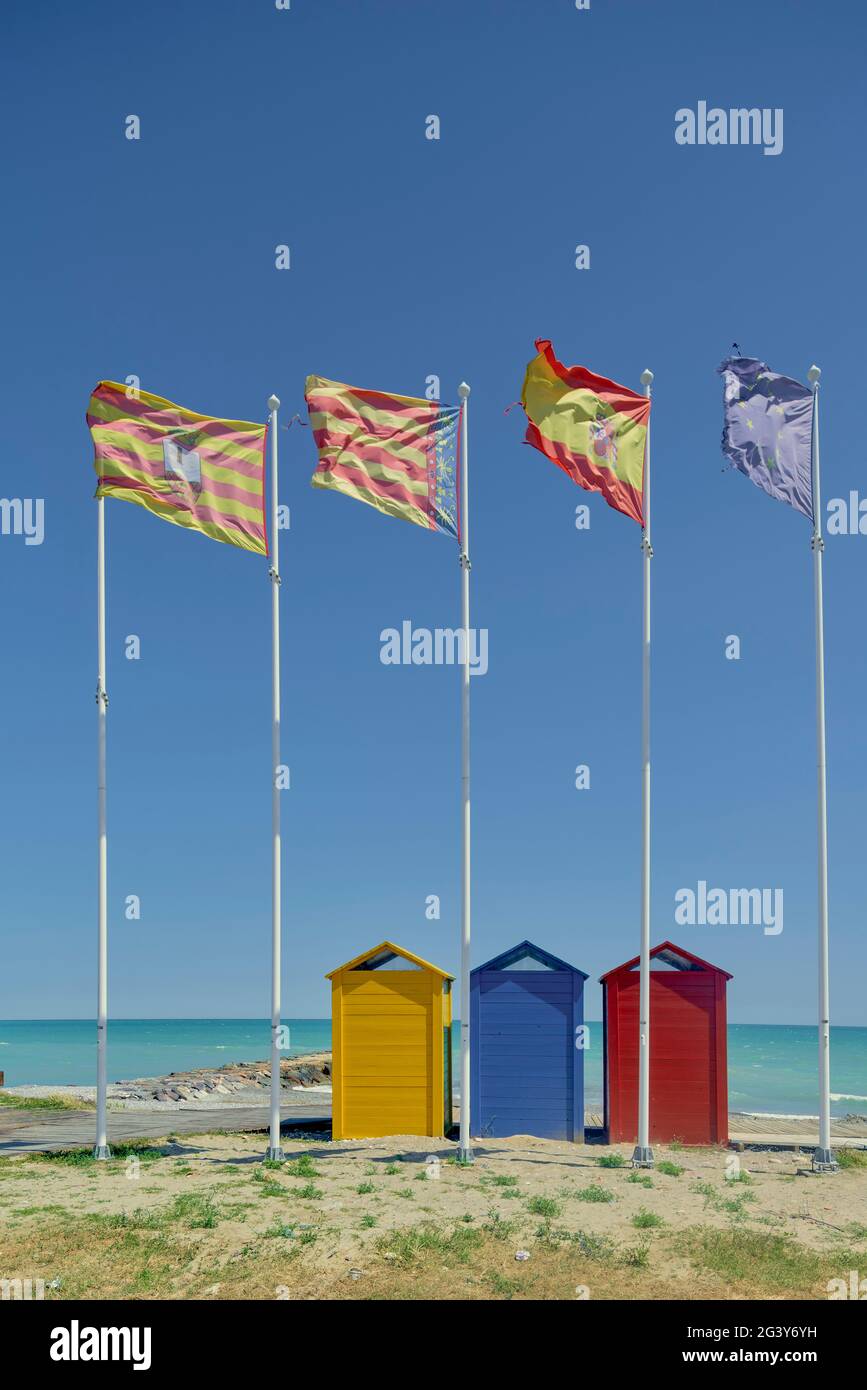 Banderas y cabañas de colores en la playa de Moncofa Costa del Azahar en la provincia de Castellón, España, Europa Foto de stock