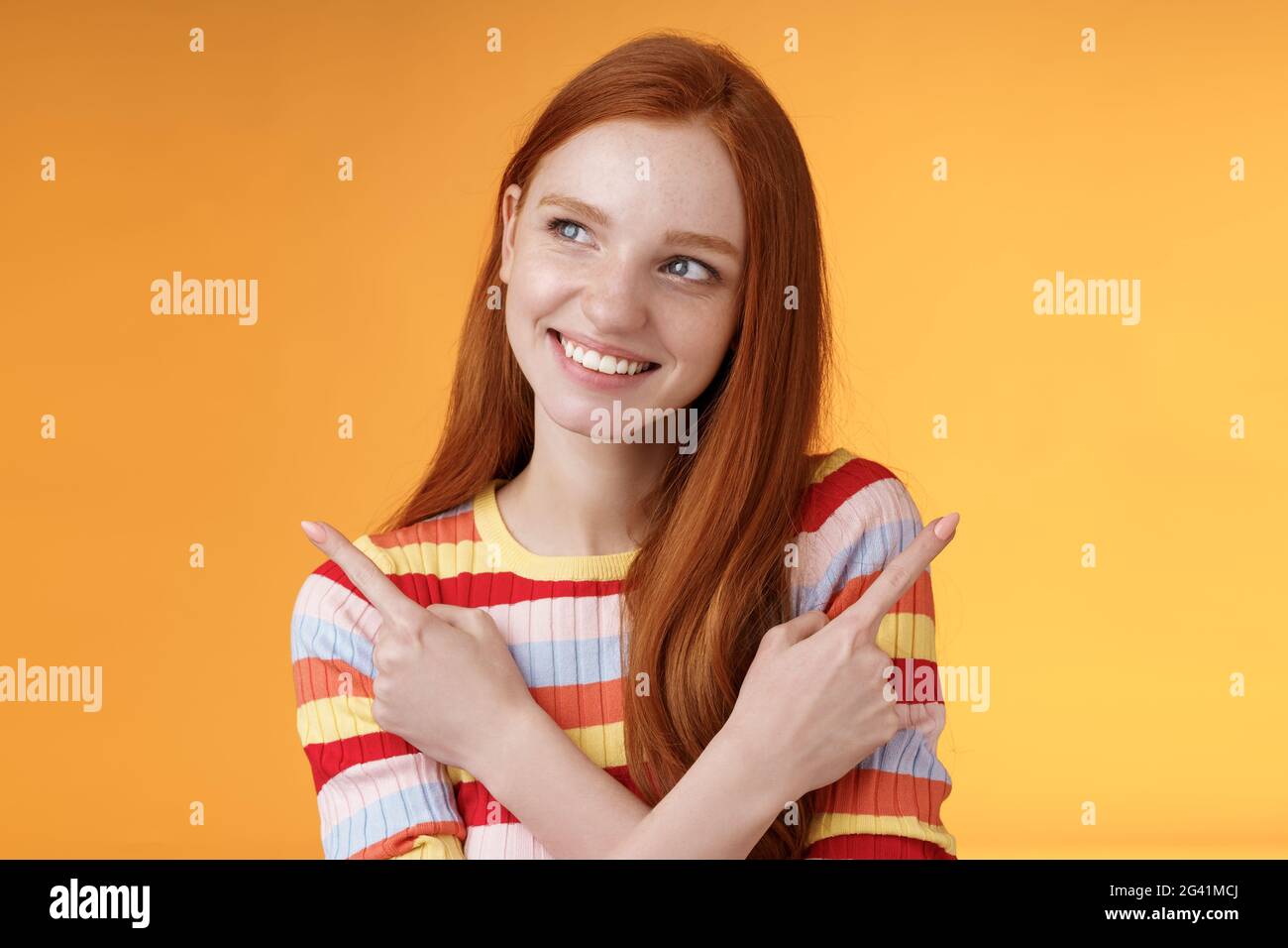 Soñador lindo Redhead chica planificación fueron ir vacaciones de verano tienen diferentes opciones de selección de la variante de mirar intrigado sonriente feliz Foto de stock