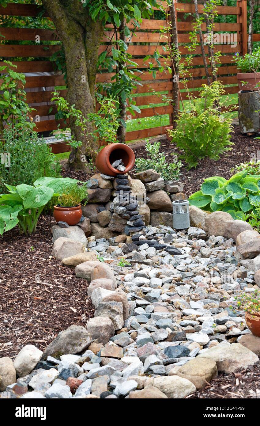 Interior al aire libre en el jardín, Fuente jarrón de cerámica con piedras  Fotografía de stock - Alamy