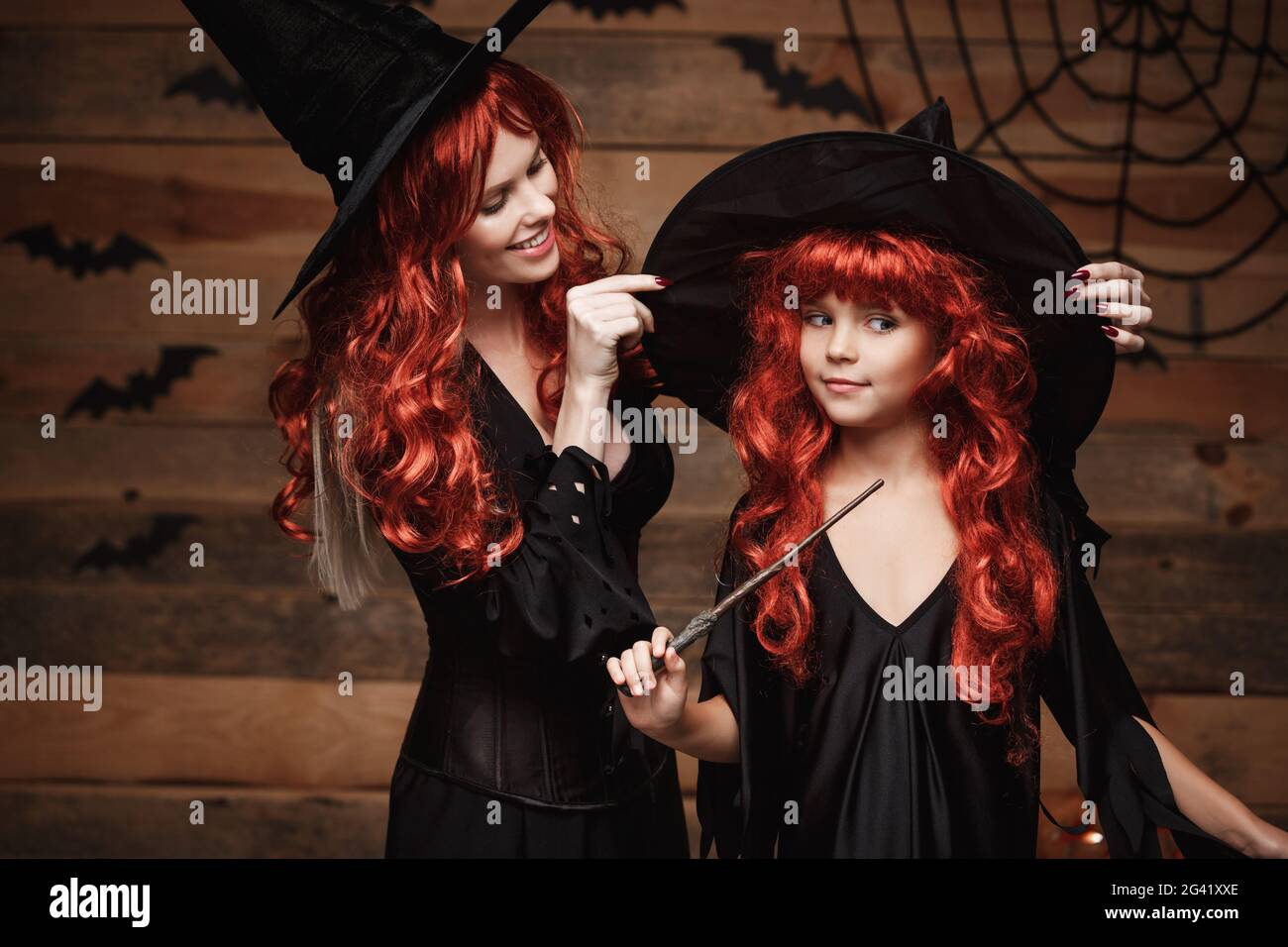 Concepto de Halloween - hermosa madre caucásica vestir para su hija en  trajes de bruja y largo cabello rizado listo para celebrar Fotografía de  stock - Alamy