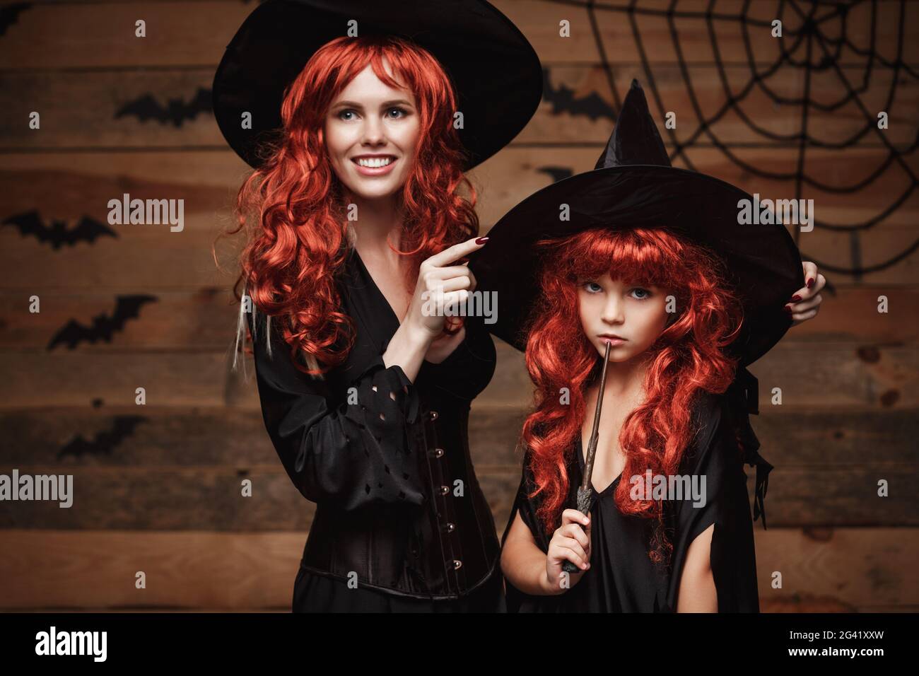 Concepto de Halloween - hermosa madre caucásica vestir para su hija en trajes de bruja y largo cabello rizado listo para celebrar Fotografía de stock - Alamy Concepto de Halloween - hermosa madre caucásica vestir para su hija en trajes de bruja y largo cabello rizado listo para celebrar Fotografía de stock - Alamy