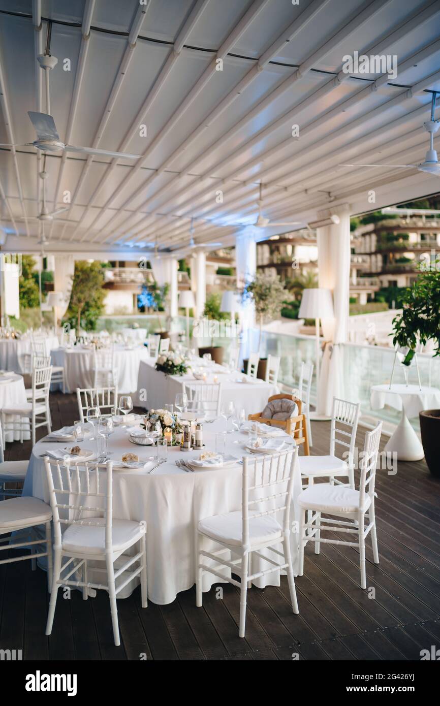 Cena de boda mesa de recepción. Mesa redonda para banquetes con mantel  blanco y sillas Chiavari blancas. Boda bajo la tienda Fotografía de stock -  Alamy