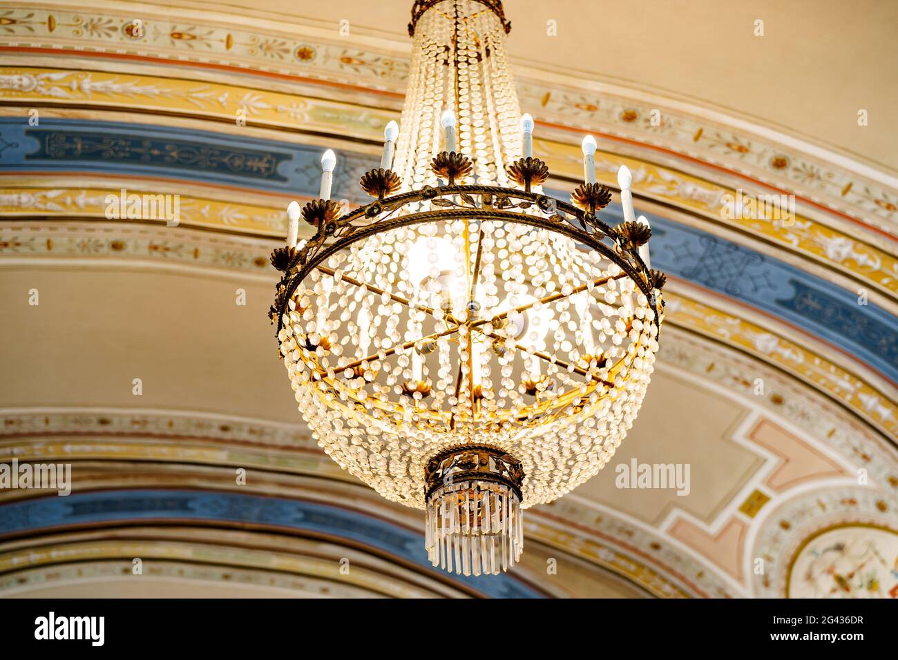 Candelabro antiguo con adornos de cristal y velas bajo el techo pintado  Fotografía de stock - Alamy