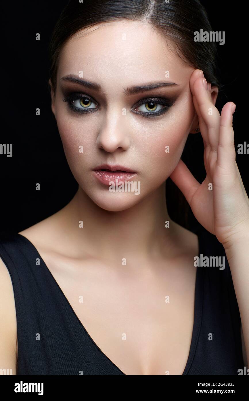 Retrato de la belleza de la mujer joven. Chica morena con maquillaje  femenino por la noche y vestido negro Fotografía de stock - Alamy