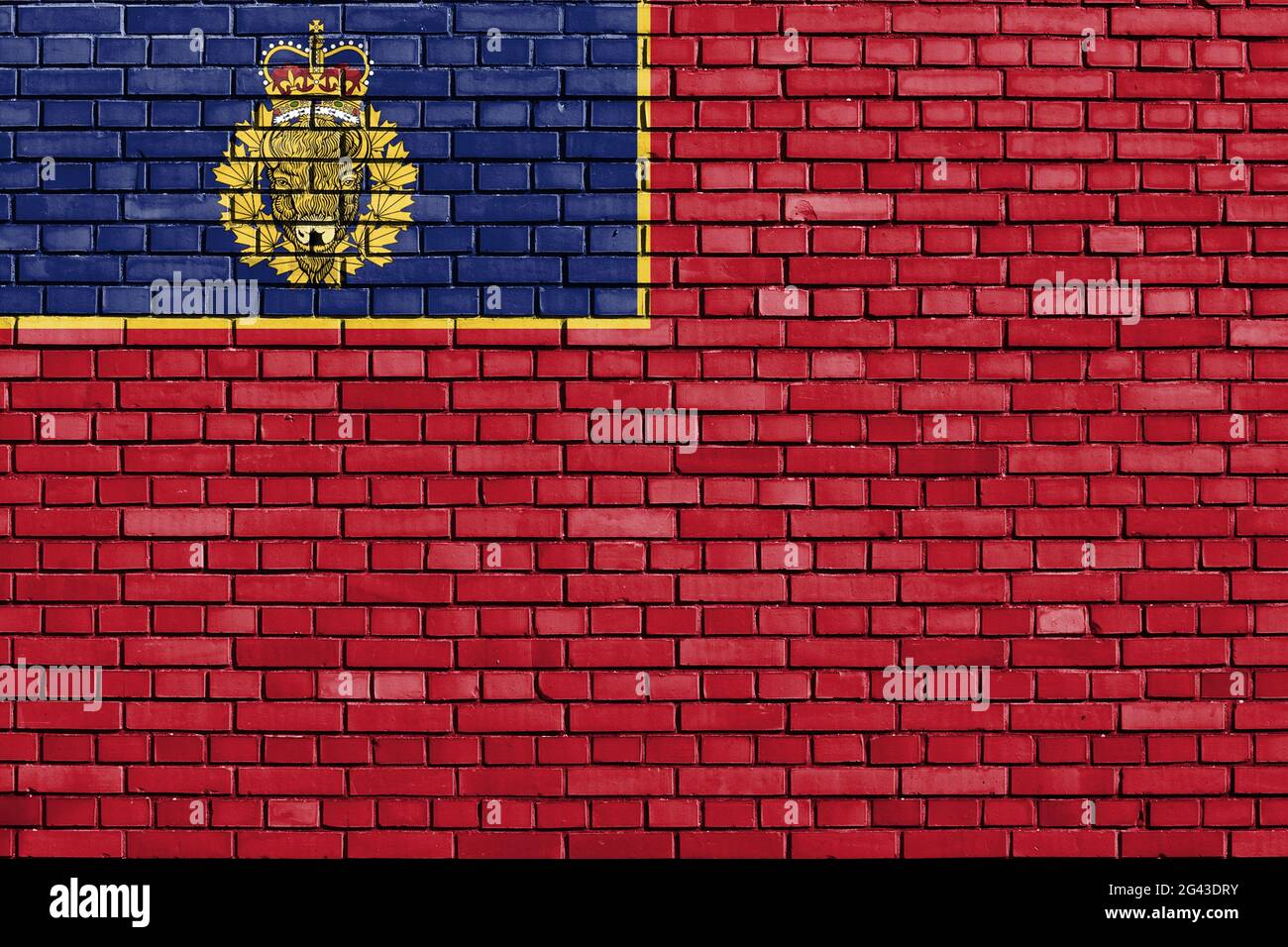 Bandera de la Policía Montada Real Canadiense pintada en la pared de ladrillo Foto de stock