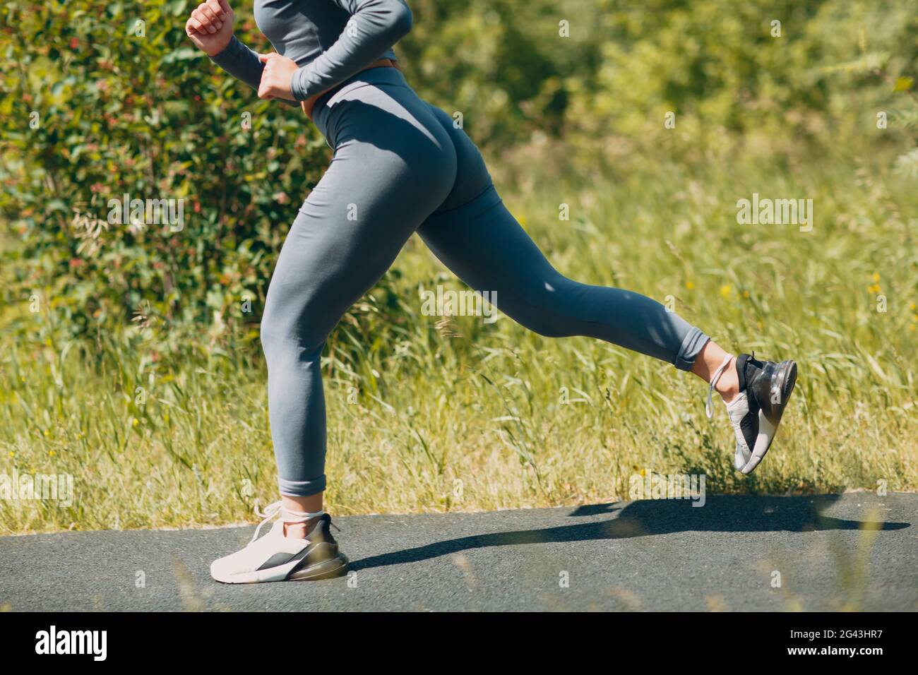 Mujer joven en ropa deportiva y zapatillas para correr en el parque